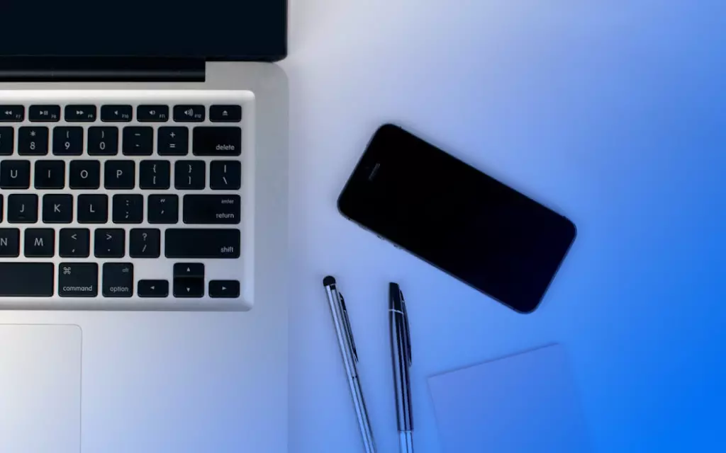 laptop z telefonem na biurku
