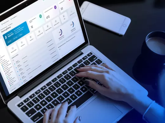osoba siedząca przy laptopie na ekranie widoczny panel systemu web360