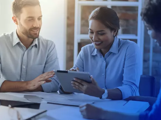 grupa szczęśliwych ludzi patrzących na tablet