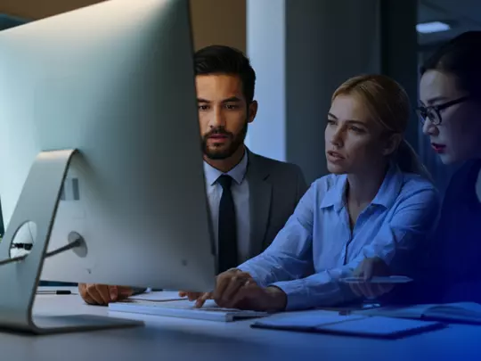 ludzie ubrani w garnitury patrzący w monitor